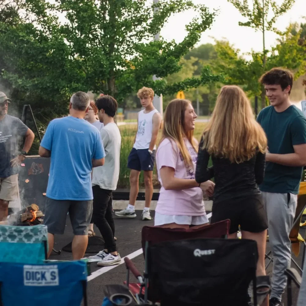 High school group discussing and socializing during an outdoor event.