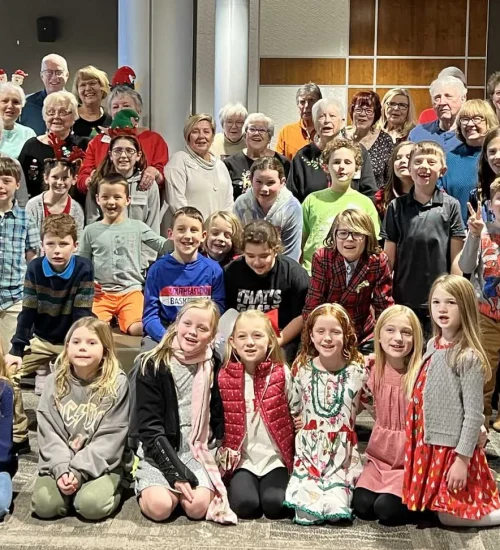 Intergenerational group of children, adults, and older adults posing for a photo at a church event.