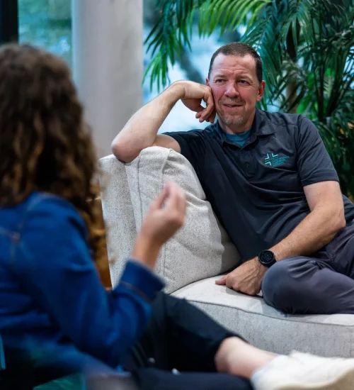 A pastor engaging in a friendly conversation with a congregant inside Carmel Cornerstone Church, symbolizing fellowship and connection.
