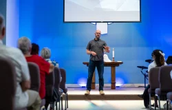 Pastor delivering a sermon at the front of the church, Eagle Creek location.