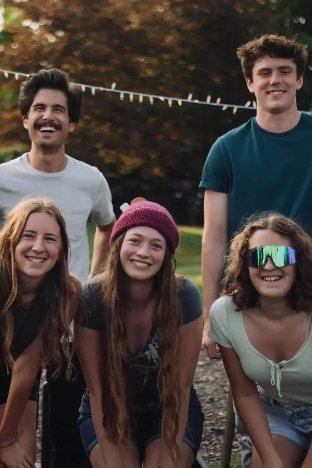 Teenagers bonding outdoors in a fun group activity with greenery in the background.
