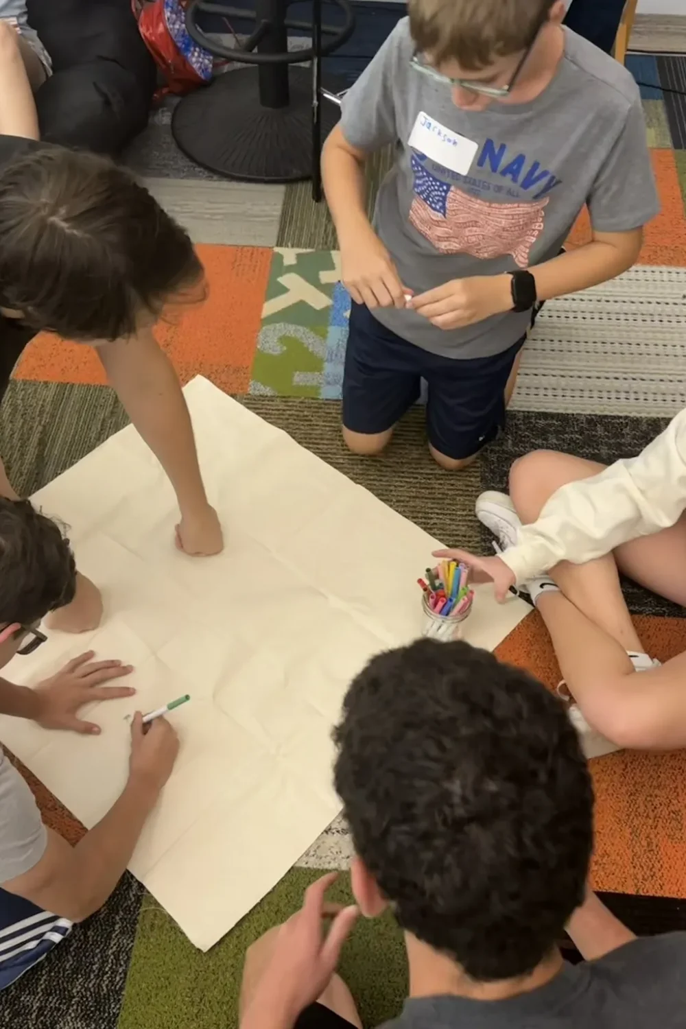 A group of teens creatively collaborating on an indoor project.